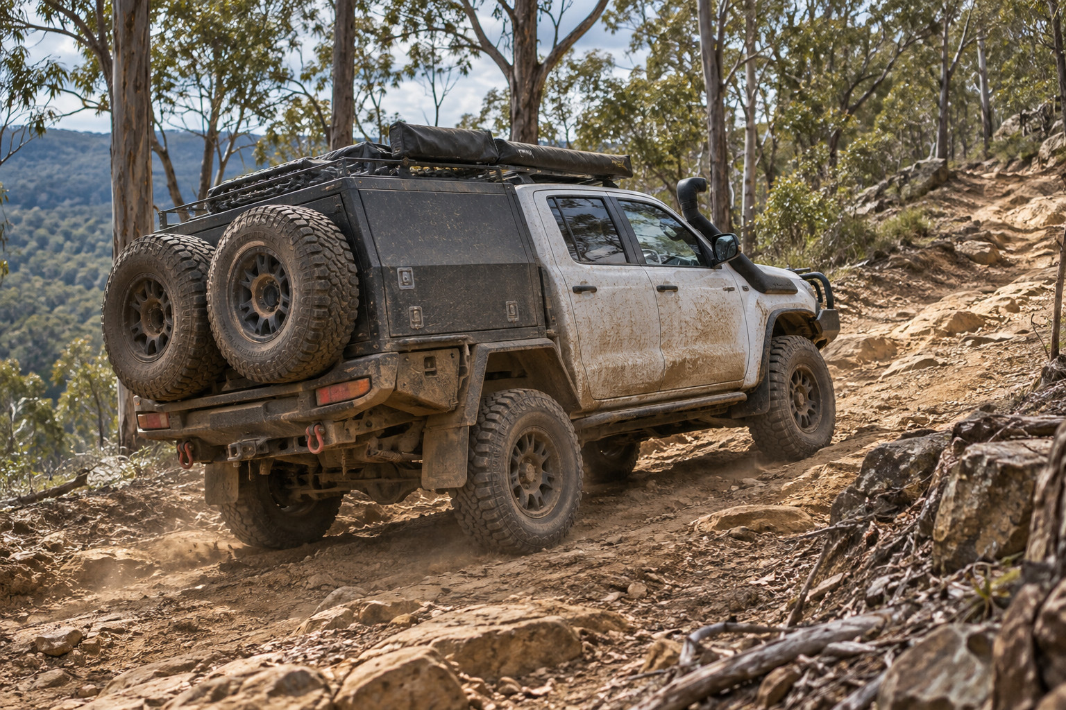 Dusty modified dual-cab 4WD ascending a steep, rutted bush track.